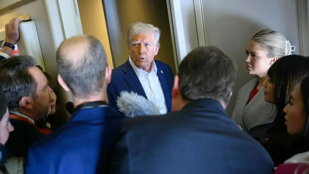 Donald Trump addressing reporters aboard Air Force One.