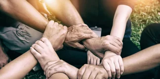Hands holding together, symbolizing kindness and humanity.