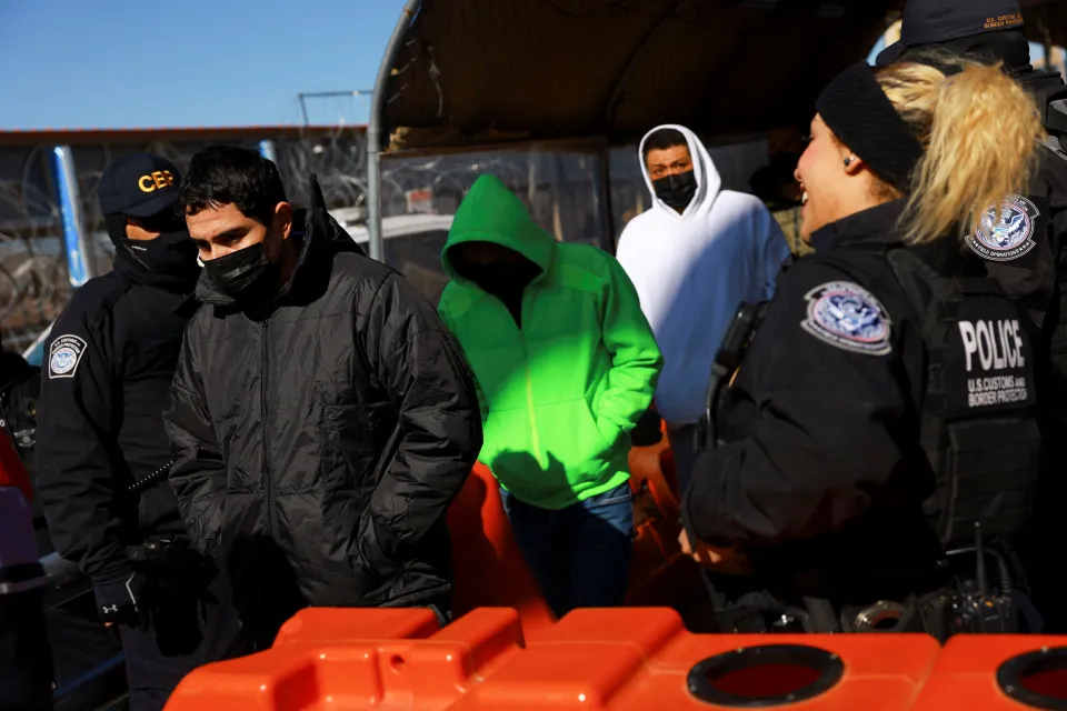 U.S. Border Patrol agents detaining individuals during a routine border security operation.