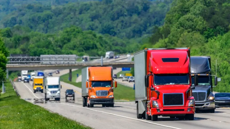 Truck carrying goods on a highway, representing supply chain logistics.