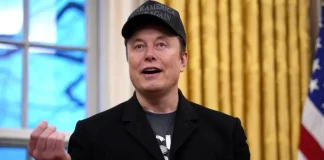 Elon Musk speaking at a conference, looking serious.